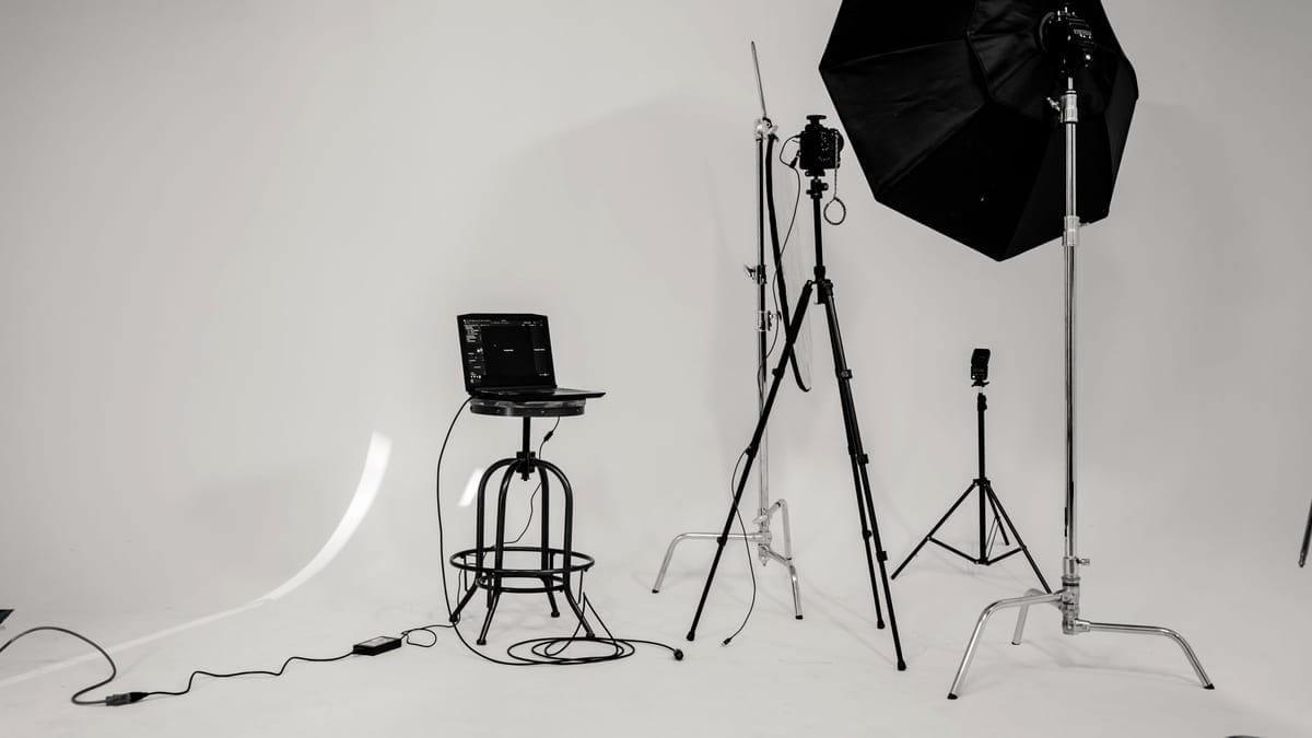 A black and white photo of a well-equipped photography studio with lighting equipment and tripods.
