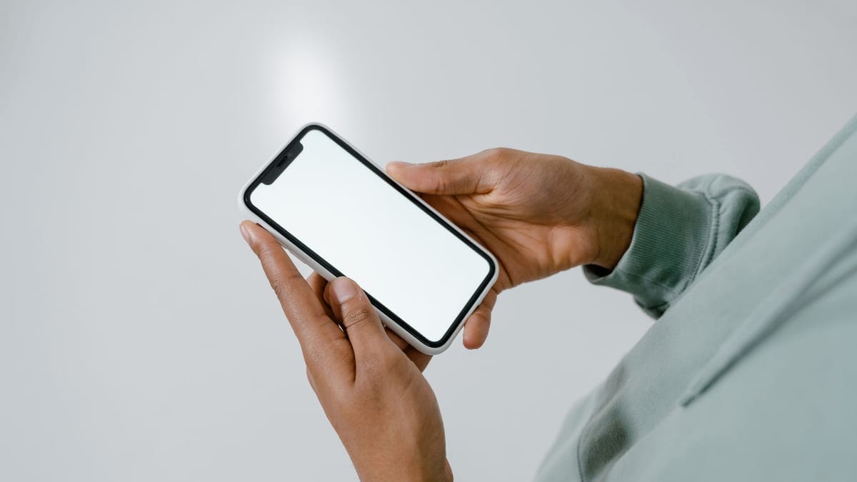 Close-up of hands holding a smartphone with a blank screen, suitable for mockups.